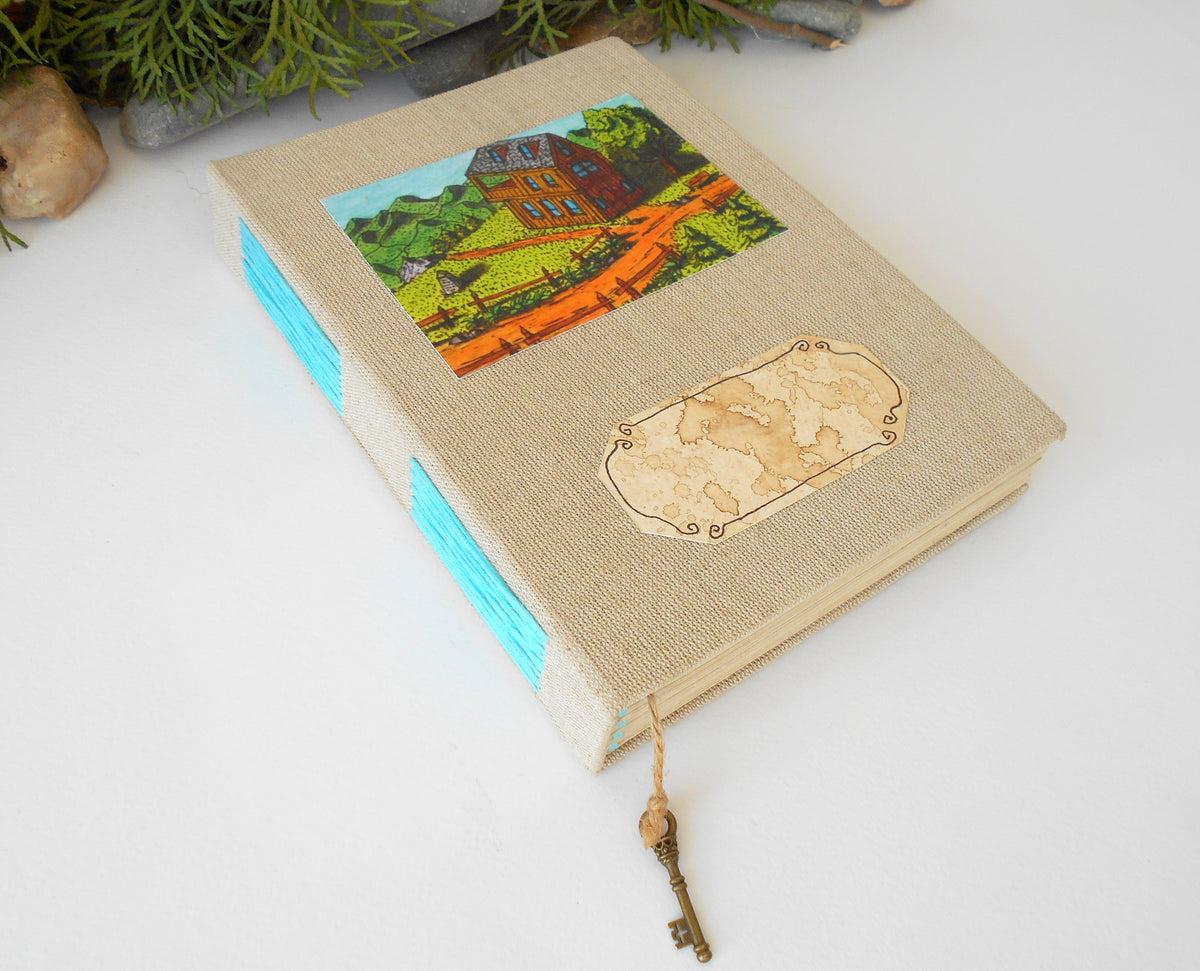 This is a handmade journal with linen fabric hardcovers and a fineÉaster Island heads art print on the front and also an empty coffee-stained title label so you can write your title on it. The art is from my art collection and is titled &#39;Gather Inn?&#39;. This journal is an inspirational book for you to use on the travel, for your daily diary journaling, or also for your planning and sketching of new projects and new poetry or novels.