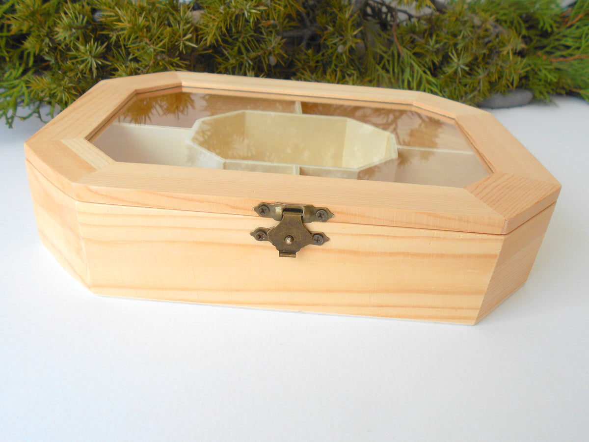 This is a wooden box with a glass display that is made of bamboo wood and that has metal hinges and closes with a bronze-color closing that may display various things like jewelry, miniatures, crystals, or other small objects of importance to you or your friends.