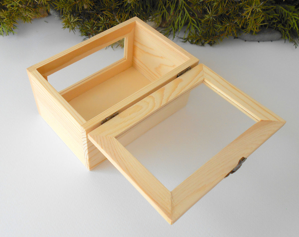 This small wooden display box is made of pinewood and has metal hinges with bronze color and the cap has a glass display so you can see what it&#39;s inside. There is another window on the front side of the box too. It has thick wooden walls and is quality made with fine pine wood materials.