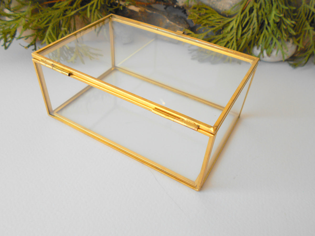 This is a small glass box made of real glass and metal edges and metal hinges that closes with a gold-color closing that may display various things like jewelry, miniatures, crystals, or other small objects of importance to you or your friends. It can be used for tiny or small terrarium projects. The edges of the box are also gold-color metal pieces.&amp;nbsp;