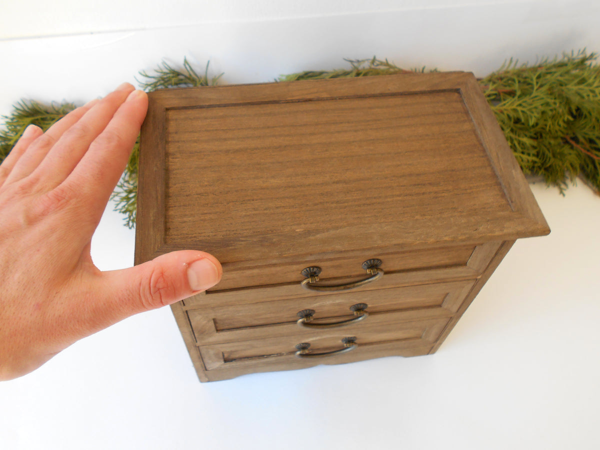 This wooden box with 3 drawers is made of bamboo wood. It has metal pulls with a vintage bronze color. The surface of the box is smooth and refined with sanding paper.