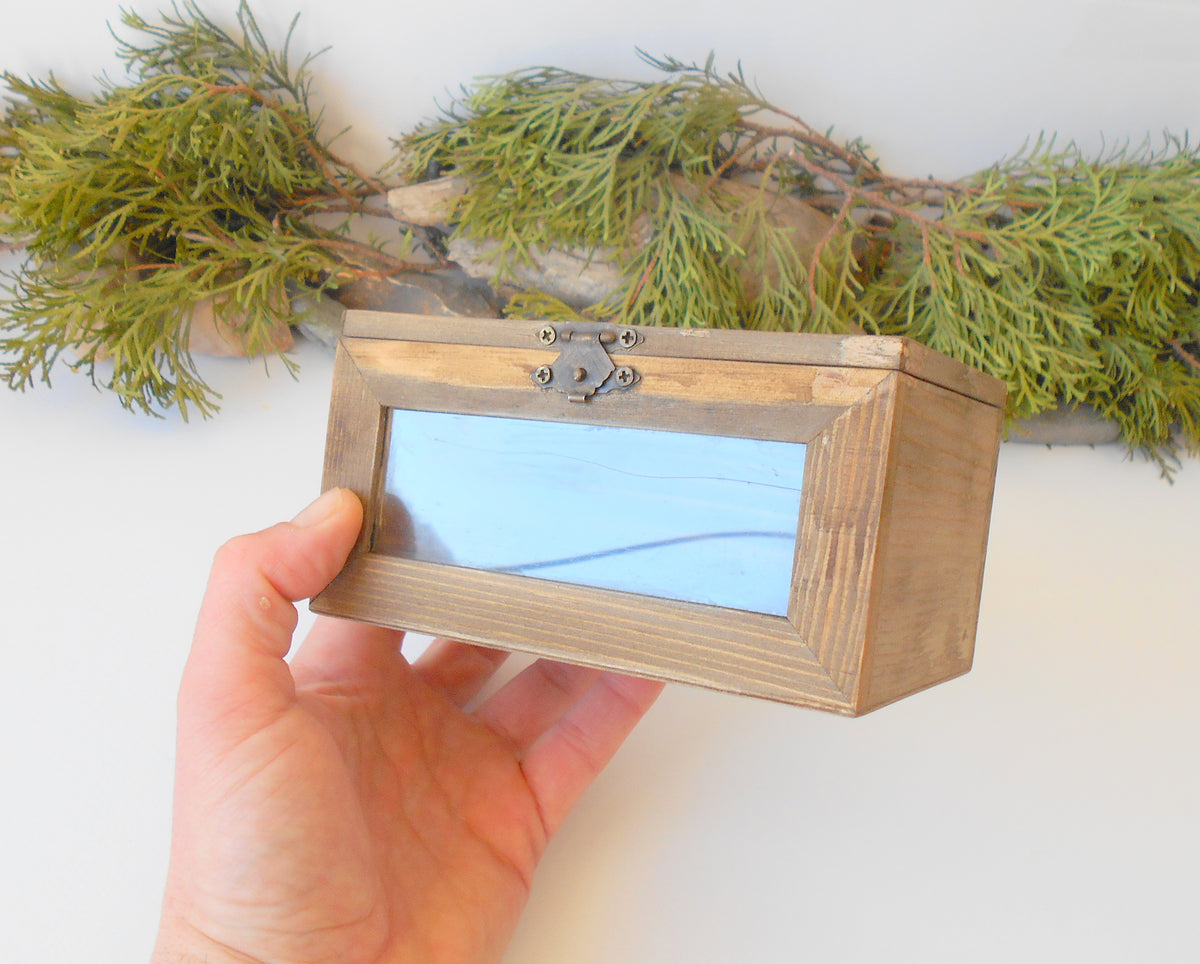 This small wooden display box is made of pinewood and has metal hinges with bronze color and the cap has 2 plastic displays so you can see what it&#39;s inside.&amp;nbsp; The second window is on the front side of the box too. It has thick wooden walls and is quality made with fine pine wood materials.