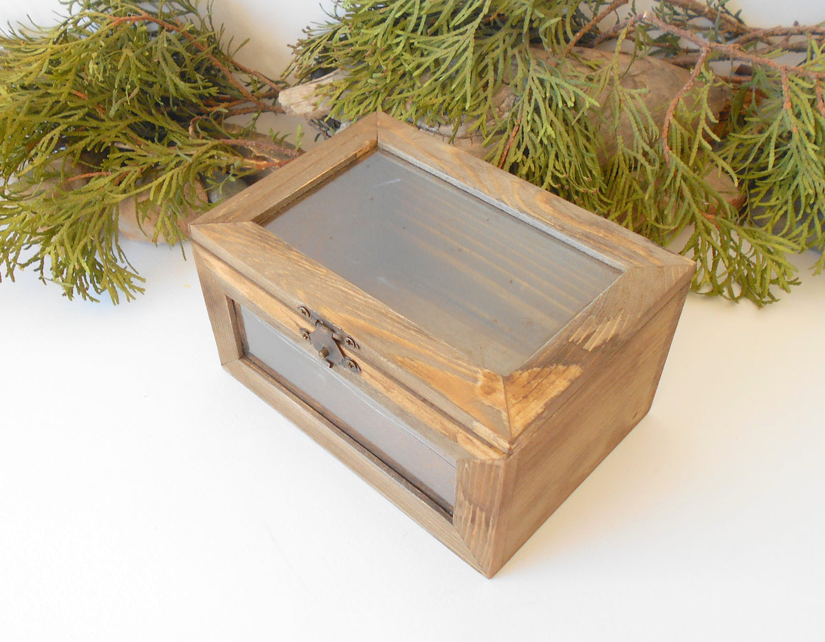 This small wooden display box is made of pinewood and has metal hinges with bronze color and the cap has 2 plastic displays so you can see what it&#39;s inside.&amp;nbsp; The second window is on the front side of the box too. It has thick wooden walls and is quality made with fine pine wood materials.