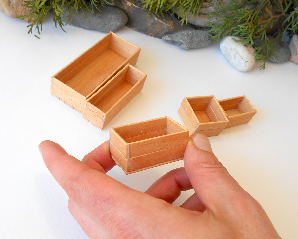 This is a set of 5 miniature boxes that are in 1/12 in scale. I craft them on order from beech popsicle sticks that I saved from being thrown away when I worked in an Ice cream factory in the Netherlands in 2023. The set consists of 5 different boxes.