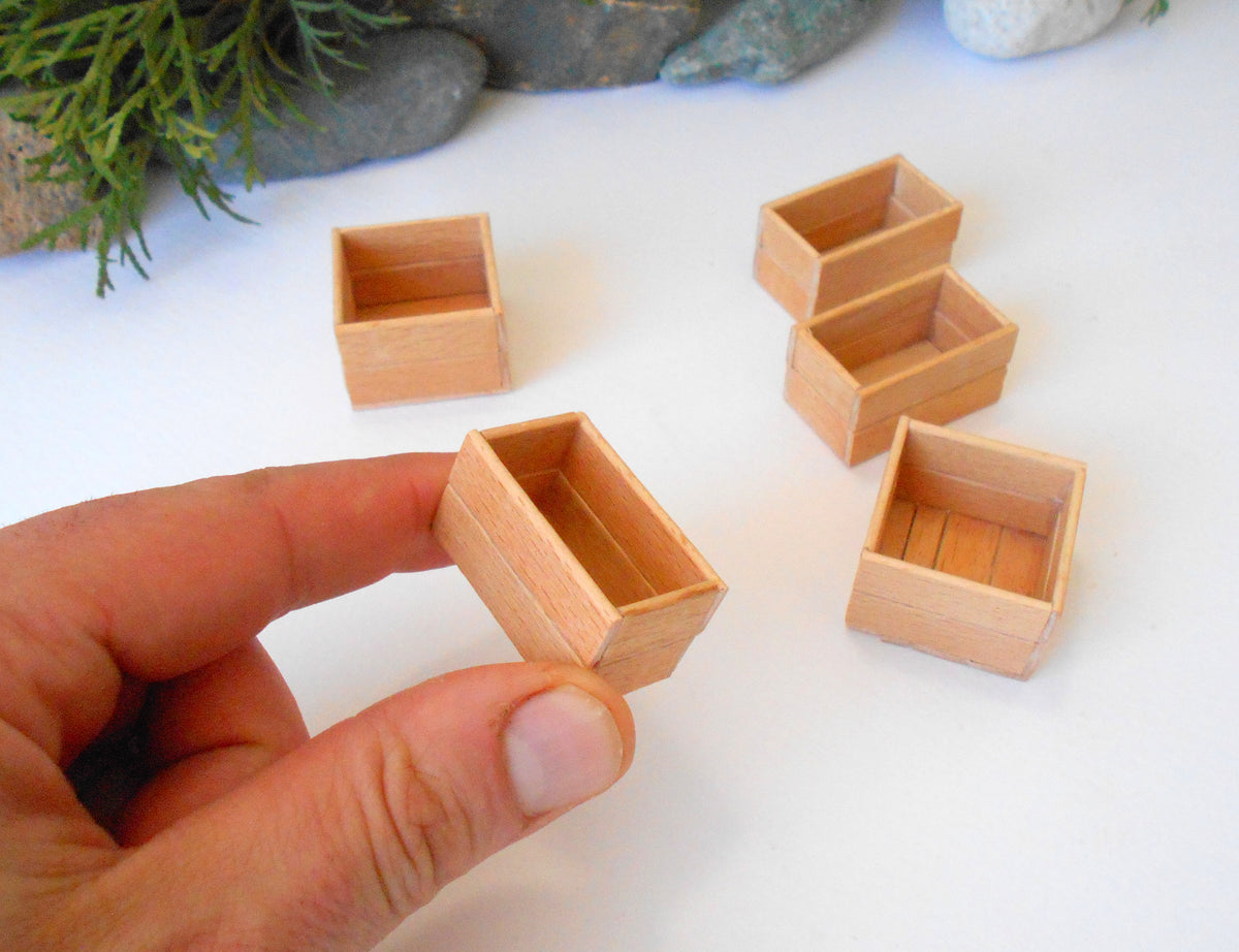 This is a set of 5 miniature boxes that are in 1/12 in scale. I craft them on order from beech popsicle sticks that I saved from being thrown away when I worked in an Ice cream factory in the Netherlands in 2023. The set consists of 2 bigger square boxes and 3 smaller rectangular boxes. 