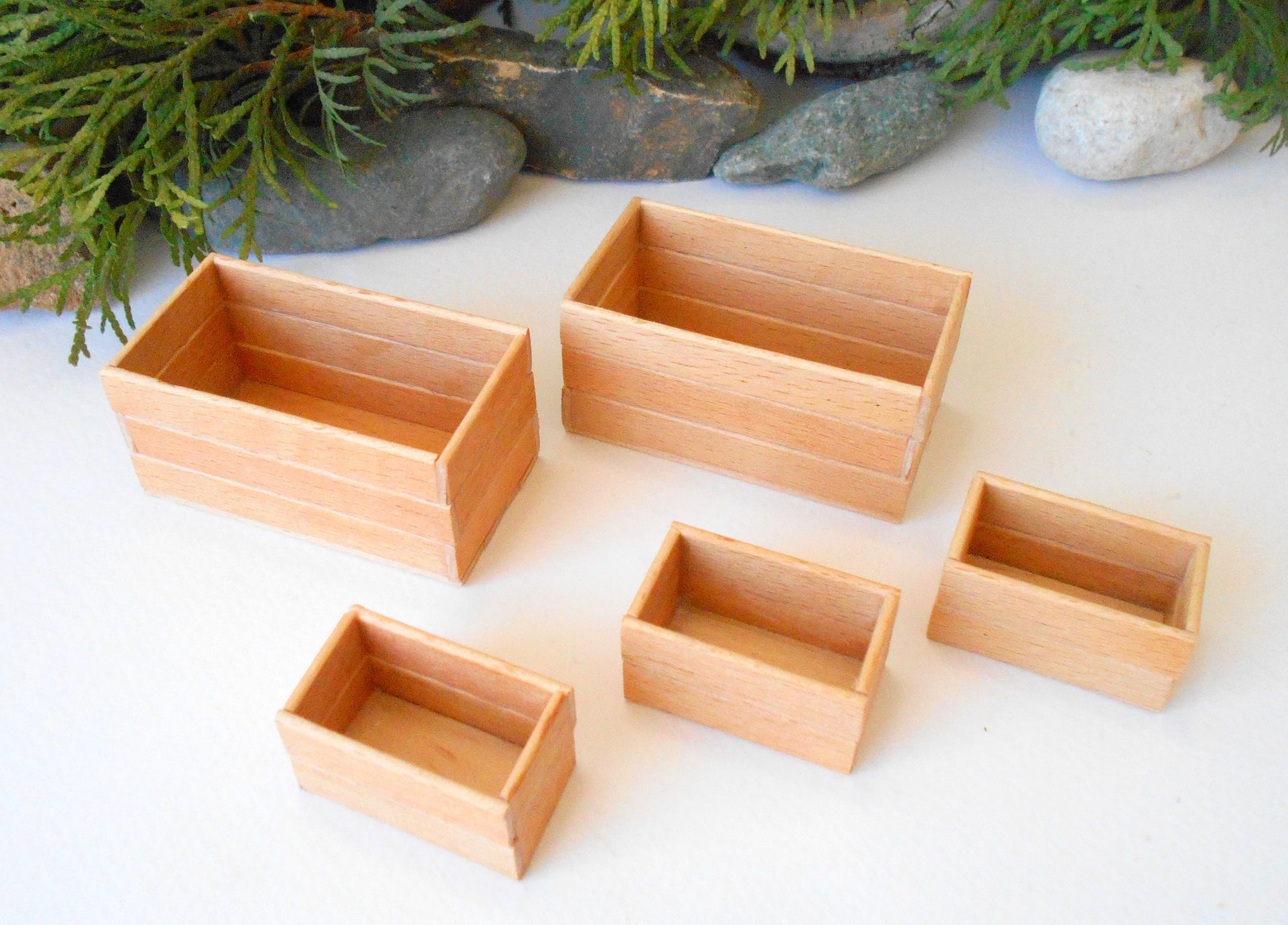 This is a set of 5 miniature boxes that are in 1/12 in scale. I craft them on order from beech popsicle sticks that I saved from being thrown away when I worked in an Ice cream factory in the Netherlands in 2023. The set consists of 2 big rectangular boxes and 3 smaller rectangular boxes.