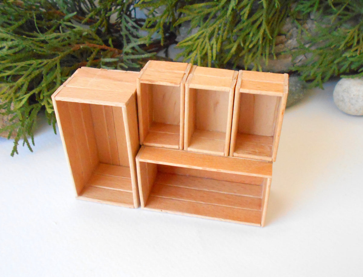 This is a set of 5 miniature boxes that are in 1/12 in scale. I craft them on order from beech popsicle sticks that I saved from being thrown away when I worked in an Ice cream factory in the Netherlands in 2023. The set consists of 2 big rectangular boxes and 3 smaller rectangular boxes.