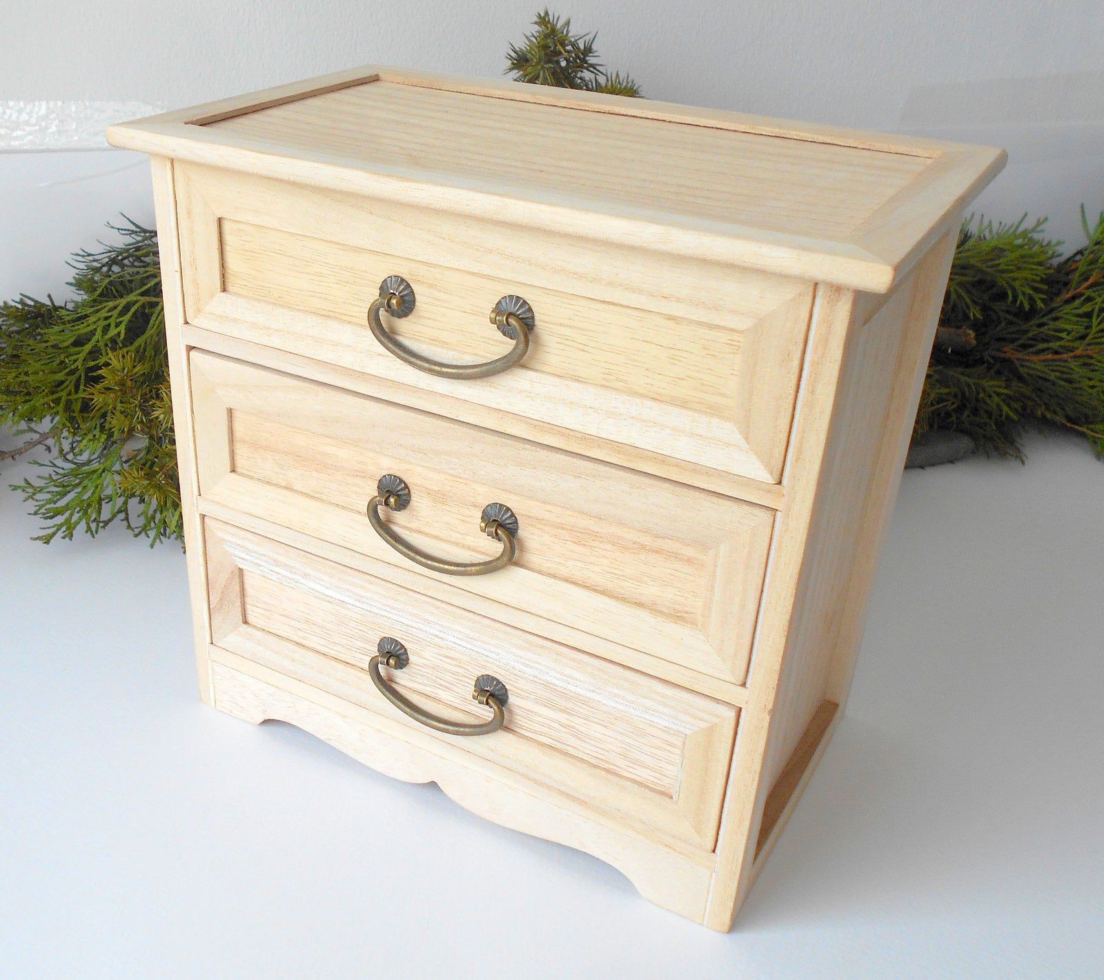 This wooden box with 3 drawers is made of bamboo wood. It has metal pulls with a vintage bronze color. The surface of the box is smooth and refined with sanding paper. The color of the box is plain pinewood color.&nbsp;