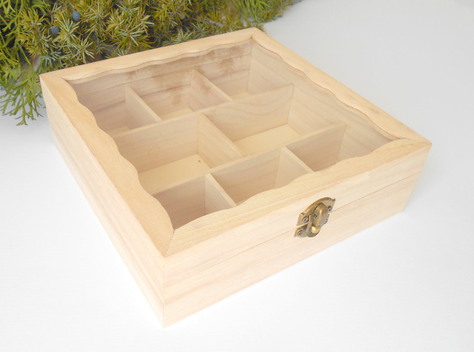 This is a wooden box with a glass display that is made of bamboo wood and that has metal hinges and closes with a bronze-color closing that may display various things like jewelry, miniatures, crystals, or other small objects of importance to you or your friends.