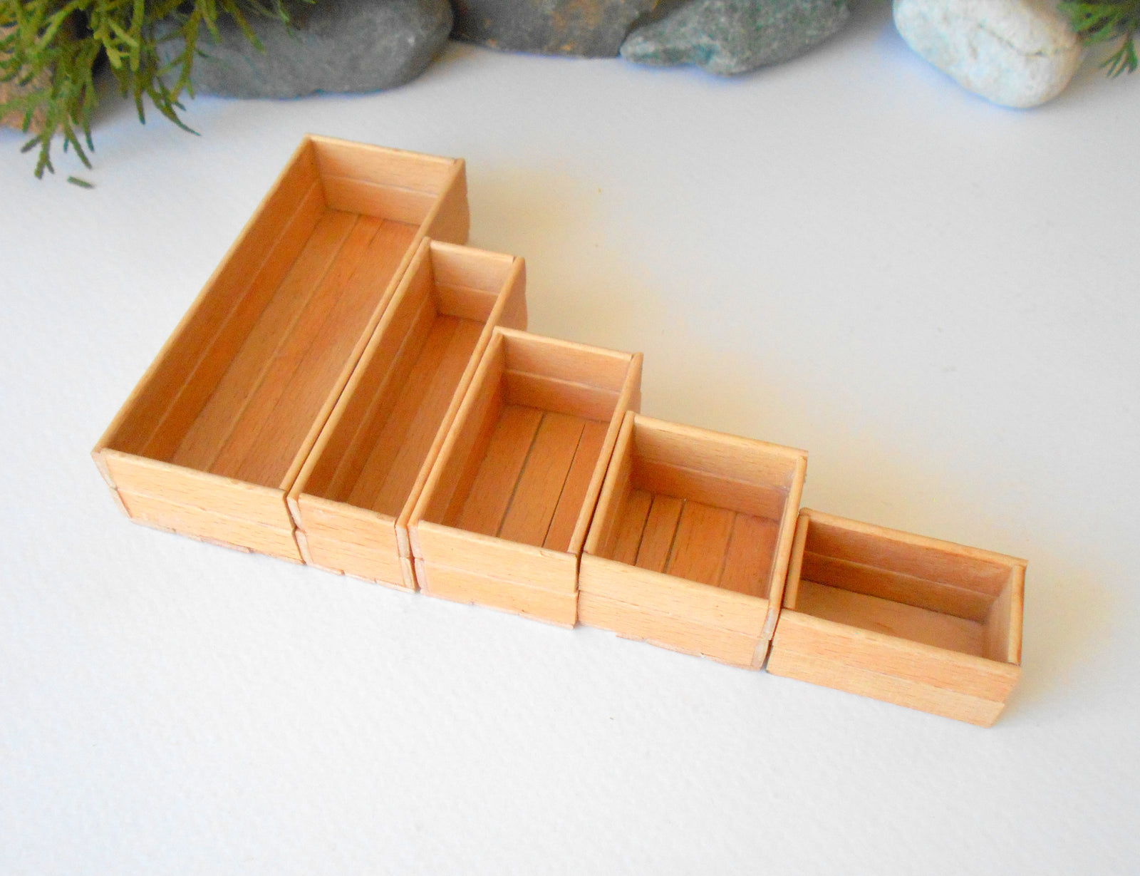 This is a set of 5 miniature boxes that are in 1/12 in scale. I craft them on order from beech popsicle sticks that I saved from being thrown away when I worked in an Ice cream factory in the Netherlands in 2023. The set consists of 5 different boxes.