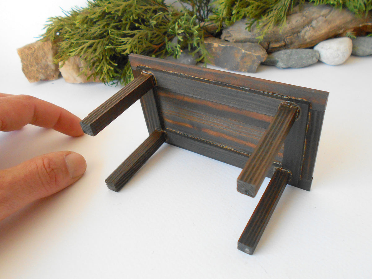 This is a handmade miniature dining or kitchen table on a&amp;nbsp;1/12th scale that is suitable for 6 mini chairs on a 1/12th scale. I handmade this table on order with real pine wood boards and beams and with water-based eco-friendly glue. I have stained that table with Italian eco-friendly mordant in dark brown.