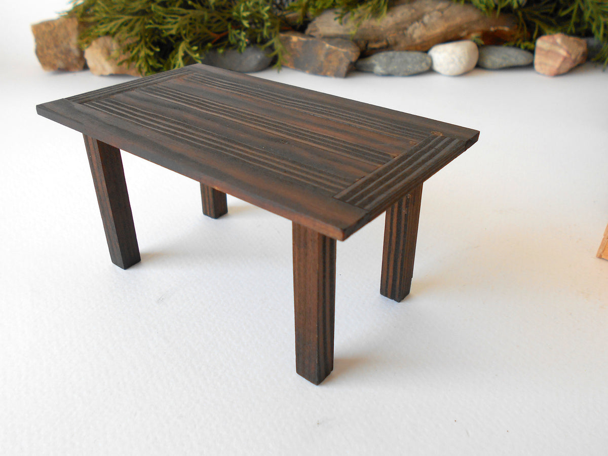 This is a handmade miniature dining or kitchen table on a&amp;nbsp;1/12th scale that is suitable for 6 mini chairs on a 1/12th scale. I handmade this table on order with real pine wood boards and beams and with water-based eco-friendly glue. I have stained that table with Italian eco-friendly mordant in dark brown.