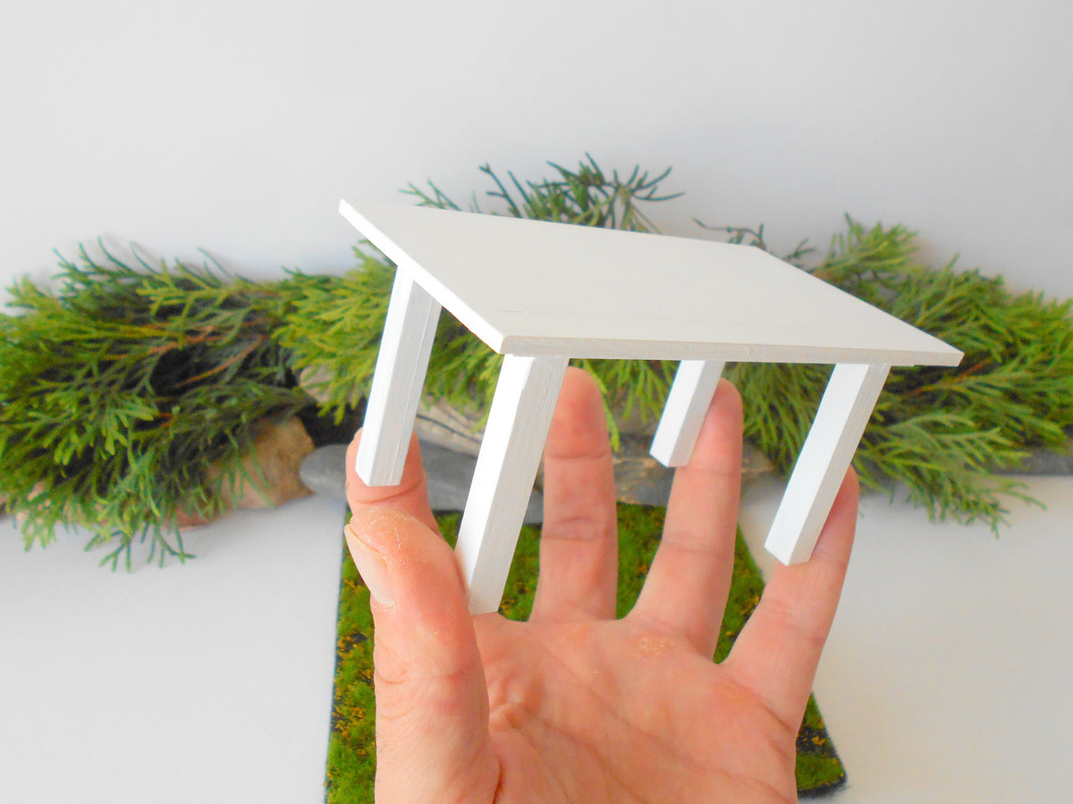 This is a handmade miniature dining or kitchen table on a&amp;nbsp;1/12th scale that is suitable for 6 mini chairs on a 1/12th scale. I handmade this table on order with real pine wood boards and beams and with water-based eco-friendly glue. I have painted the table with white acrylic paints with a smooth shiny finish.