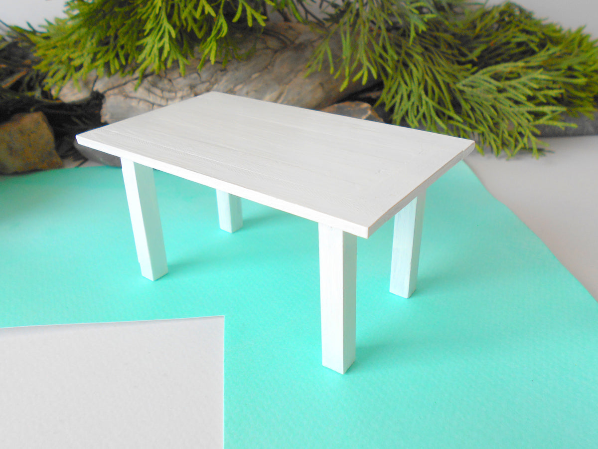 This is a handmade miniature dining or kitchen table on a&amp;nbsp;1/12th scale that is suitable for 6 mini chairs on a 1/12th scale. I handmade this table on order with real pine wood boards and beams and with water-based eco-friendly glue. I have painted the table with white acrylic paints with a smooth shiny finish.
