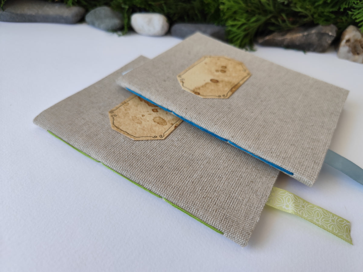 A gray handmade fabric notebook with a title label, a bookmark, Hemp Cord binding and coffee inside lining. The notebook is eco-friendly with linen gray fabric and Hemp cord as well as 100% recycled off-white blank pages.

NOTE: this is a listing for one notebook and shipping is included in the price.

Size: 5&quot; x 7&quot; ( 12.5 x 17.5 cm. )

Page number: 50 sheets - 100 pages

Color: hray

Page paper: 100 % recycled, off-white and blank pages