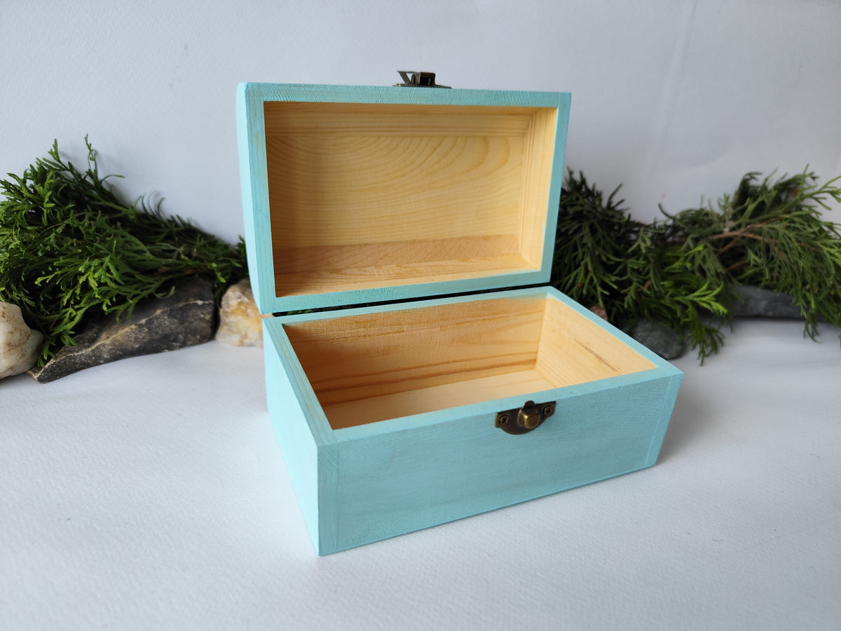 This mint painted chest wooden box is made of quality pine wood and has metal hinges with bronze-color and the cap and the body of the box have bronze-color closing. The cap of the small box is curved like in a chest box. The thickness of the box walls is 0.3 inches which makes the box strong and lasting. I have refined and sanded the box to have smooth surface and I have colored it with a mint light blue color that I developed myself with white, blue,  and green acrylic paints.